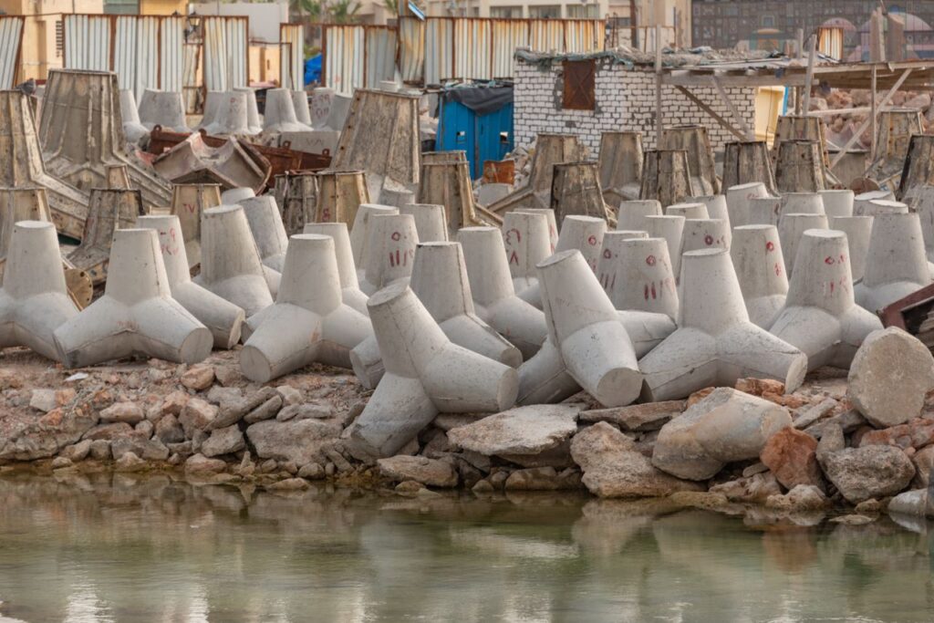 Concrete tetrapods lining the industrial coastline for erosion control and coastal protection.