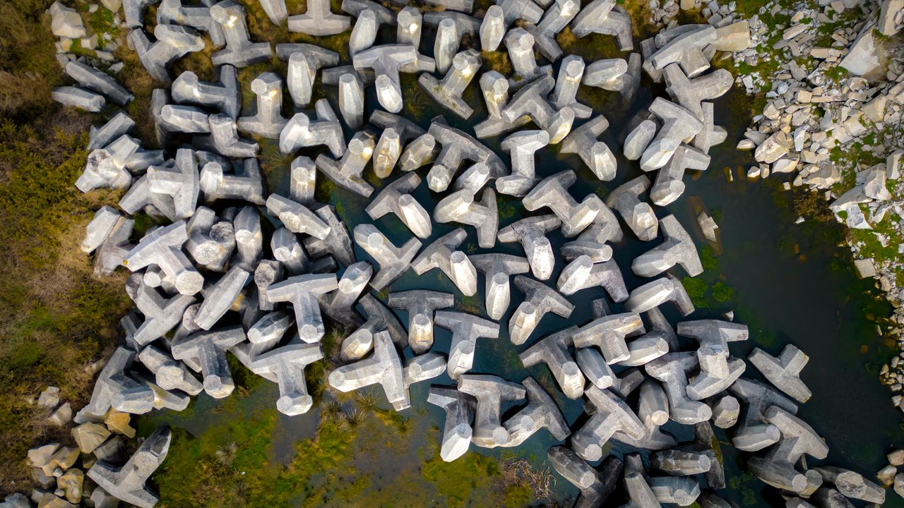 Aerial photograph showcasing dolos structures near the coast in Lugo, Spain, under daylight.